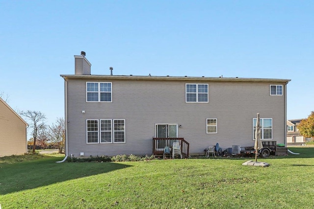 rear view of property featuring central AC unit and a lawn