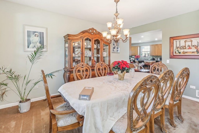 dining area featuring carpet and an inviting chandelier