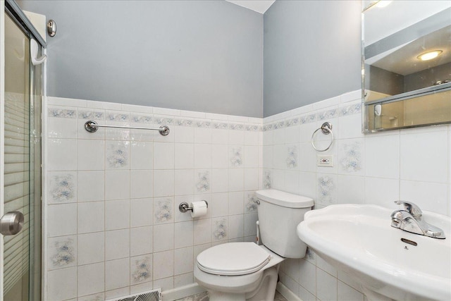 bathroom featuring an enclosed shower, toilet, tile walls, and sink