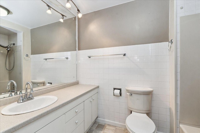 bathroom featuring vanity, a shower, toilet, and tile walls