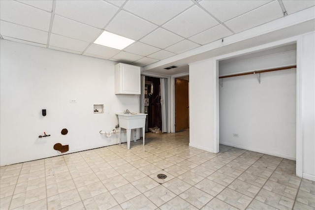 interior space featuring a drop ceiling and sink