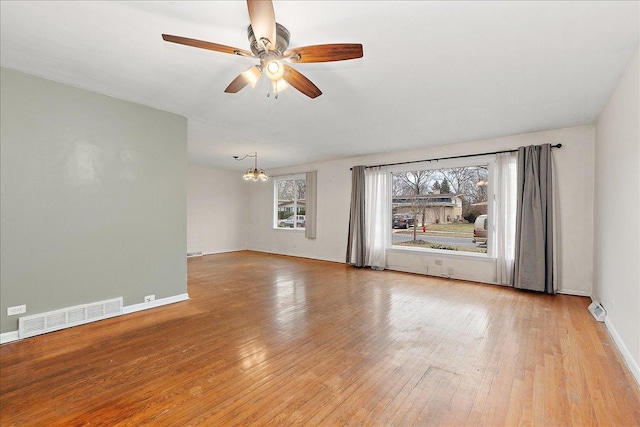 empty room featuring light hardwood / wood-style flooring and ceiling fan with notable chandelier