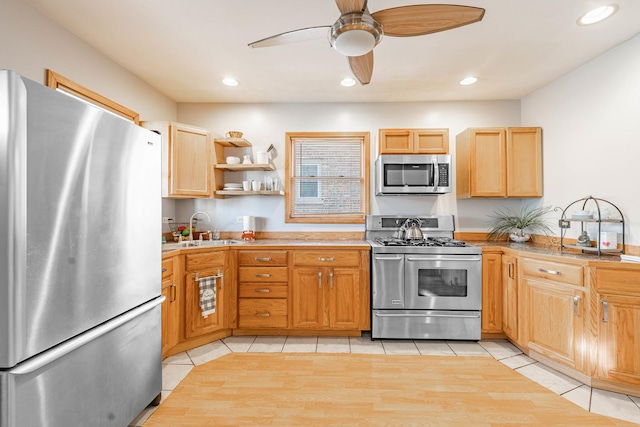 kitchen featuring ceiling fan, light tile patterned floors, sink, and appliances with stainless steel finishes