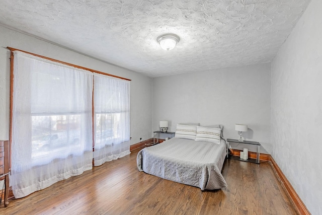 bedroom featuring wood-type flooring and a textured ceiling