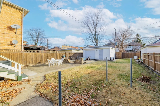 view of yard featuring an outbuilding, a patio, and a garage