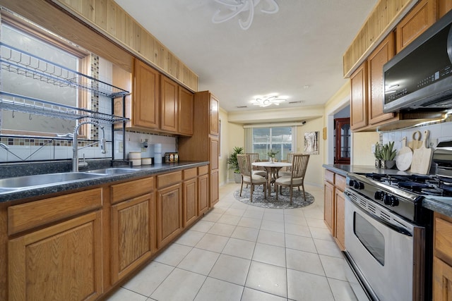 kitchen featuring backsplash, light tile patterned flooring, sink, and stainless steel appliances