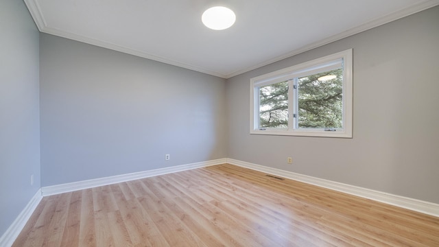 spare room featuring light hardwood / wood-style flooring and ornamental molding