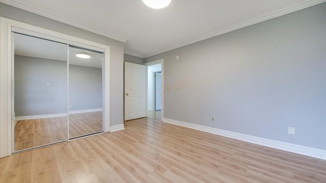 unfurnished bedroom featuring light hardwood / wood-style flooring, a closet, and ornamental molding