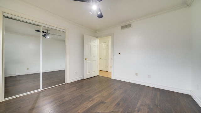 unfurnished bedroom featuring ornamental molding, a closet, ceiling fan, and dark wood-type flooring