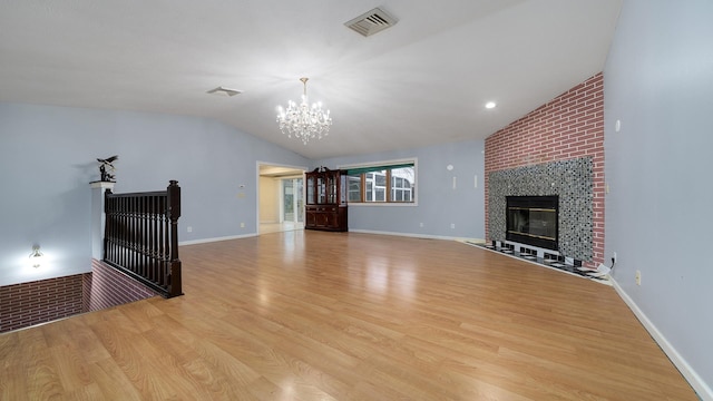 unfurnished living room featuring a large fireplace, light hardwood / wood-style floors, and vaulted ceiling