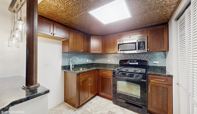 kitchen with sink, hanging light fixtures, black gas range oven, backsplash, and dark stone counters