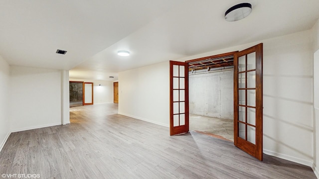 spare room with light wood-type flooring and french doors