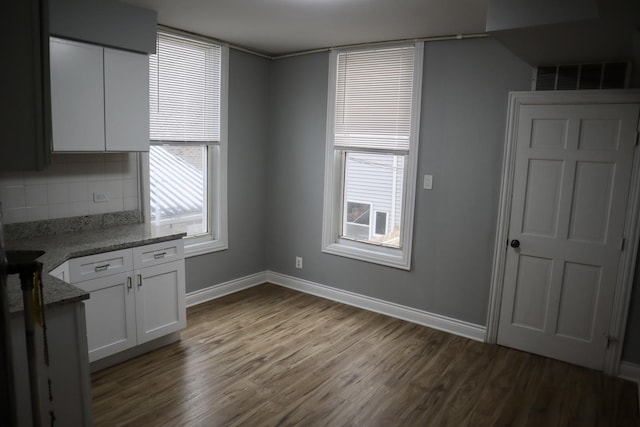 unfurnished dining area featuring dark hardwood / wood-style flooring