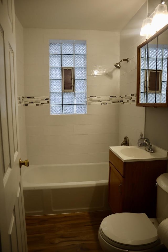 full bathroom featuring tiled shower / bath, toilet, vanity, and hardwood / wood-style flooring