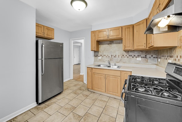 kitchen with decorative backsplash, sink, light tile patterned floors, stainless steel refrigerator, and range with gas stovetop