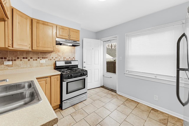 kitchen featuring light brown cabinetry, sink, tasteful backsplash, and stainless steel range with gas stovetop