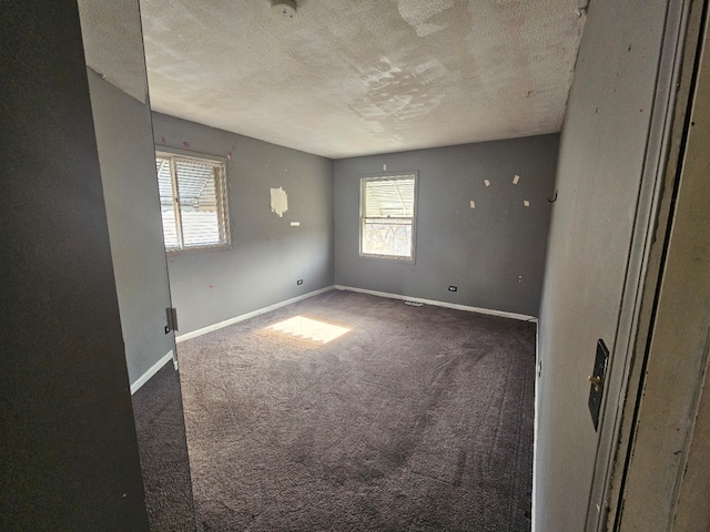 carpeted empty room with a textured ceiling