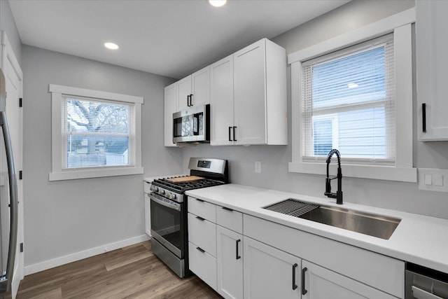 kitchen featuring a healthy amount of sunlight, white cabinets, and stainless steel appliances