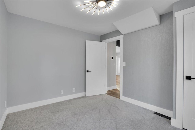 unfurnished bedroom with carpet flooring and a chandelier