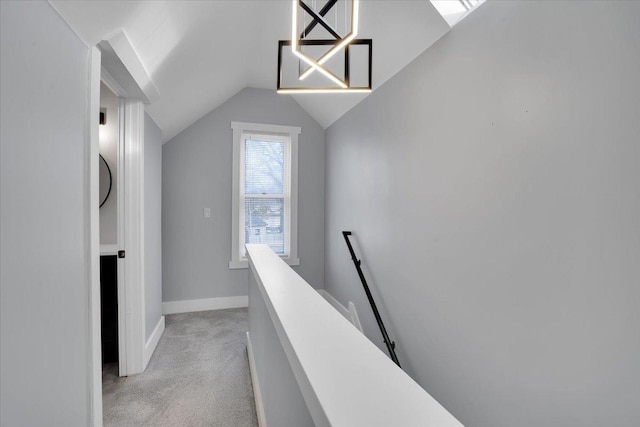 corridor featuring light carpet and vaulted ceiling