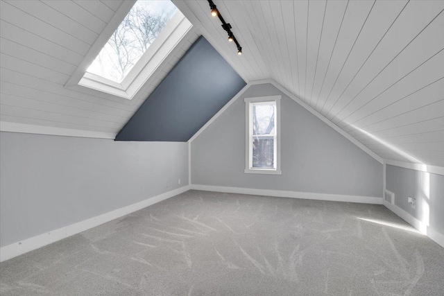 bonus room featuring light colored carpet, lofted ceiling with skylight, and wood ceiling