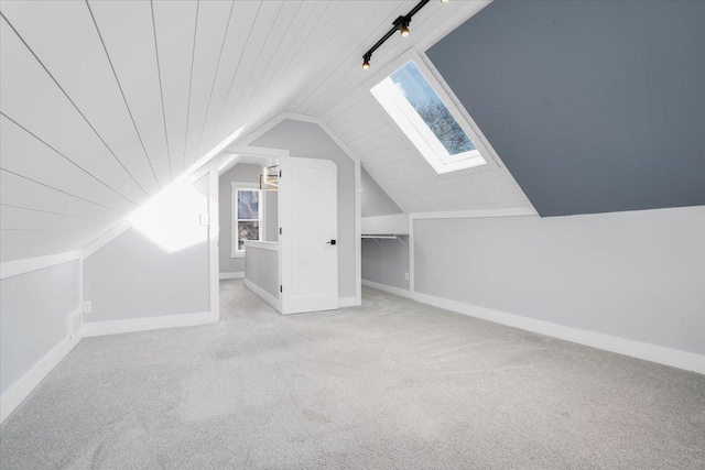 bonus room featuring vaulted ceiling with skylight, wooden ceiling, and light carpet