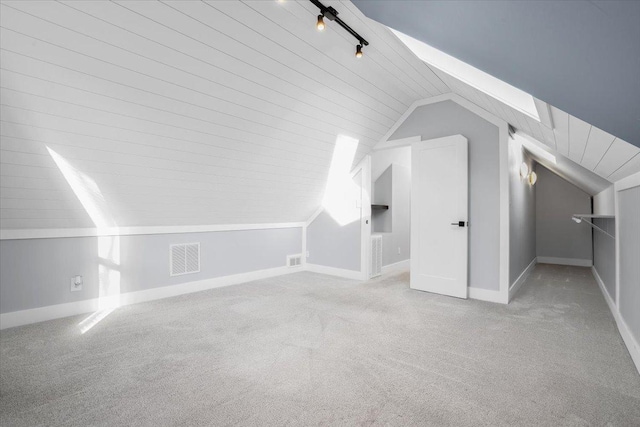 additional living space with light colored carpet and vaulted ceiling