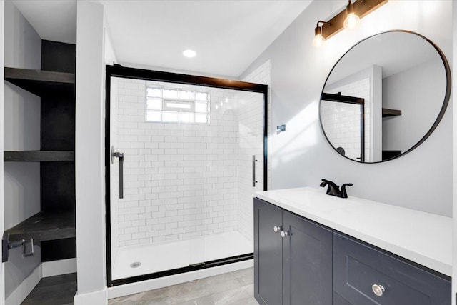 bathroom with tile patterned flooring, vanity, and a shower with door