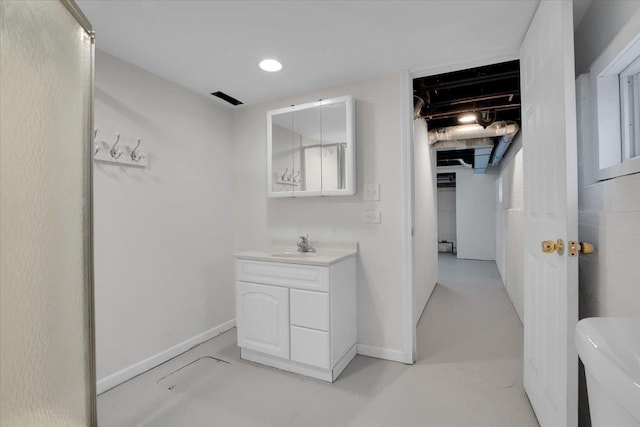 bathroom featuring vanity, toilet, and concrete floors