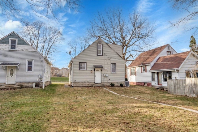 rear view of property featuring a lawn