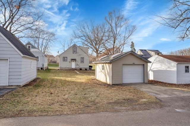 view of side of property with a yard, an outbuilding, and a garage