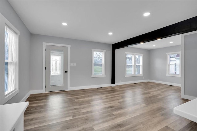 foyer entrance with beamed ceiling and light hardwood / wood-style floors