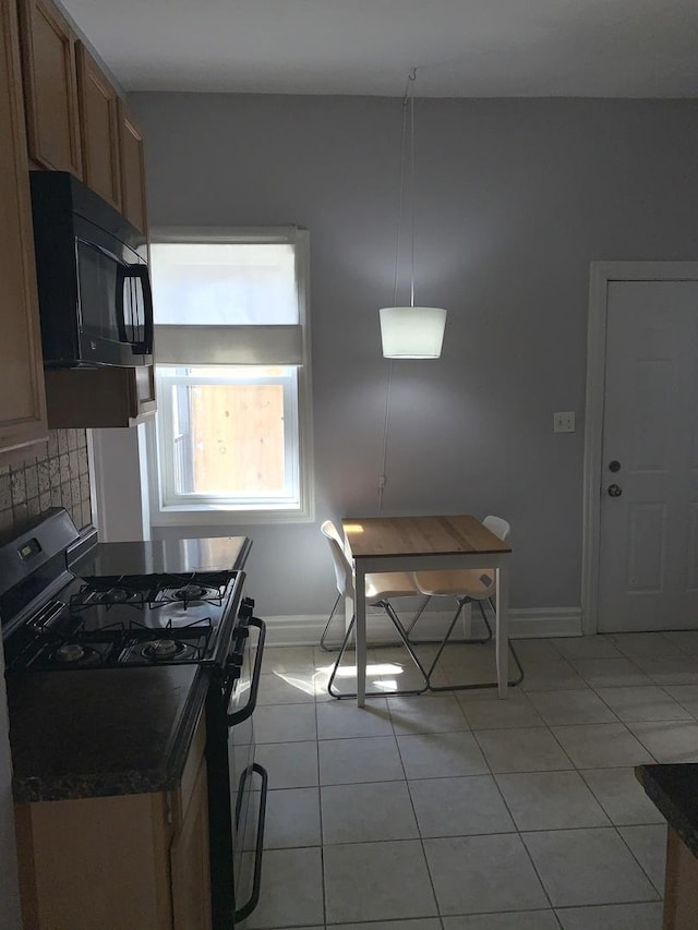 kitchen with backsplash, black range with gas stovetop, light tile patterned flooring, and hanging light fixtures