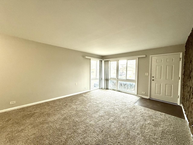 unfurnished room featuring dark carpet