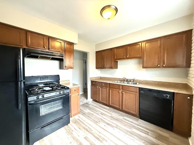 kitchen featuring sink, black appliances, and light hardwood / wood-style floors