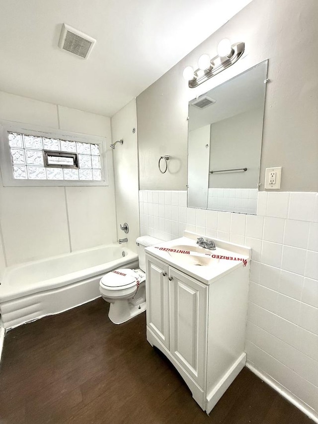 full bathroom with vanity, wood-type flooring, toilet, tile walls, and shower / bath combination