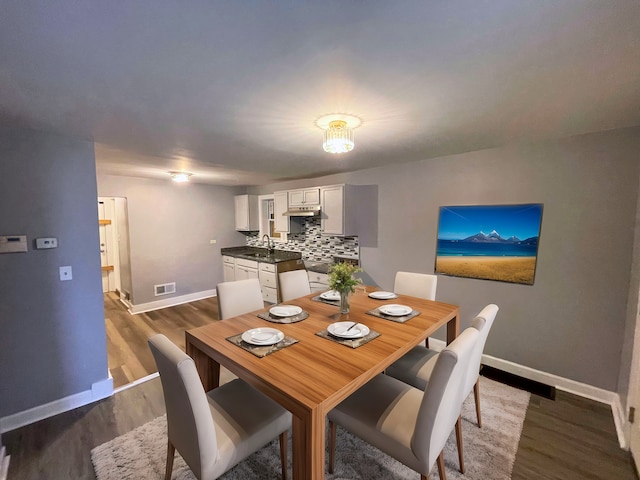 dining space with wood-type flooring and sink