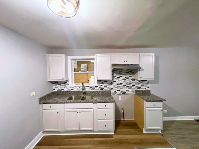 kitchen with dark hardwood / wood-style flooring, tasteful backsplash, white cabinetry, and sink