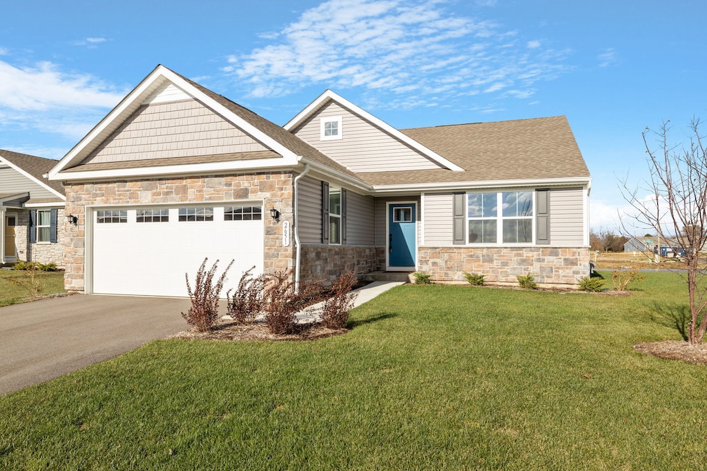 craftsman house with a garage and a front lawn