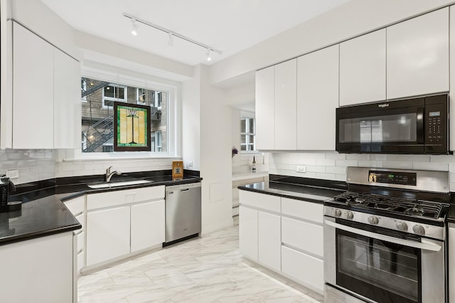 kitchen with sink, white cabinets, tasteful backsplash, and appliances with stainless steel finishes