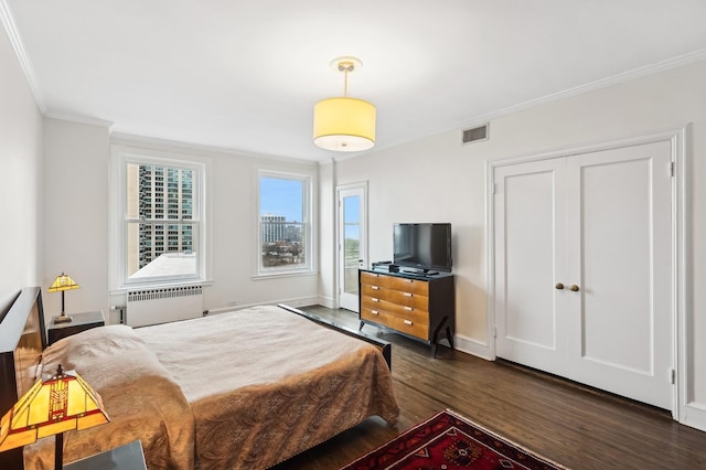 bedroom featuring ornamental molding, radiator, and dark hardwood / wood-style flooring