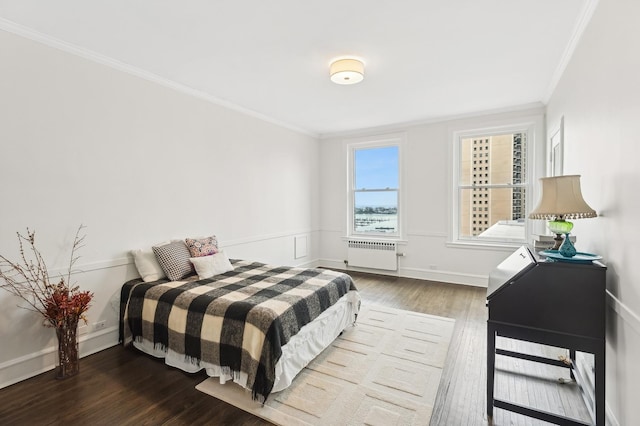 bedroom with radiator heating unit, ornamental molding, and hardwood / wood-style flooring