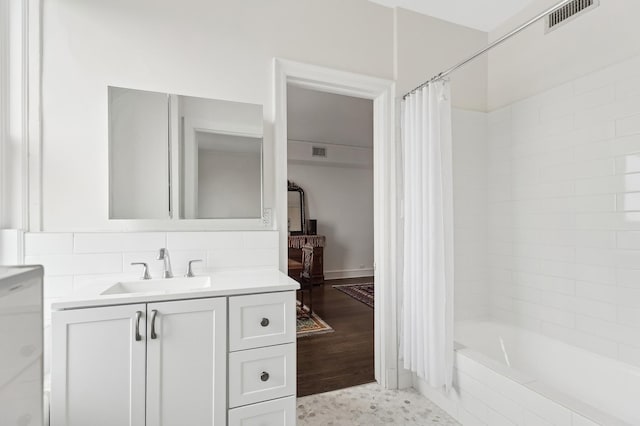 bathroom featuring shower / bath combination with curtain, tasteful backsplash, and vanity