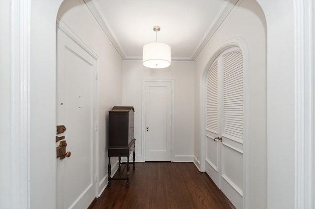 hallway with dark wood-type flooring and crown molding