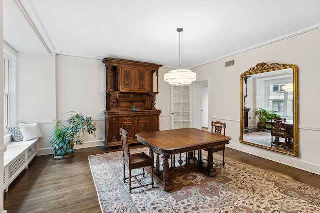 dining space featuring dark wood-type flooring and ornamental molding