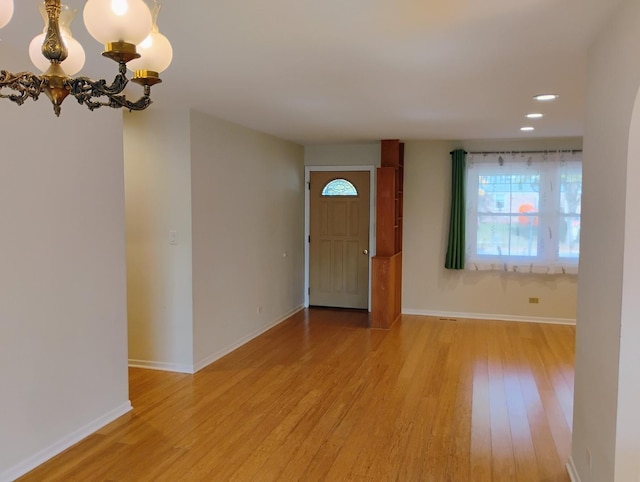 foyer with a notable chandelier and light wood-type flooring