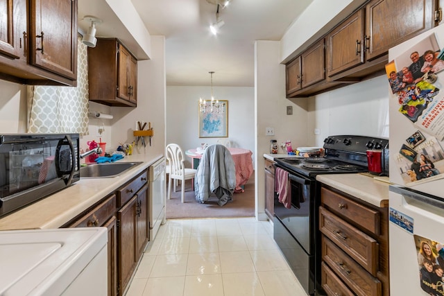 kitchen with pendant lighting, black appliances, sink, an inviting chandelier, and light tile patterned floors