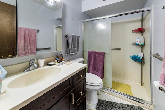 bathroom featuring an enclosed shower, vanity, and toilet