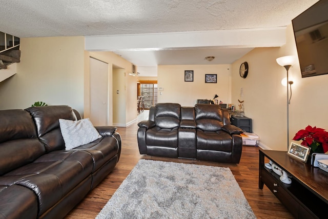 living room featuring beam ceiling, hardwood / wood-style floors, and a textured ceiling