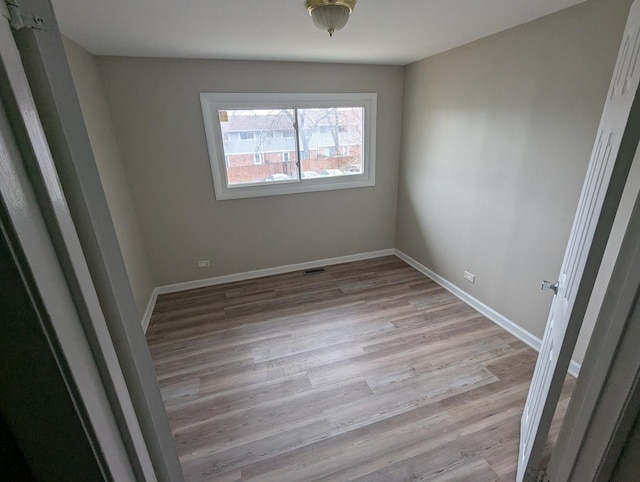 unfurnished room with light wood-type flooring